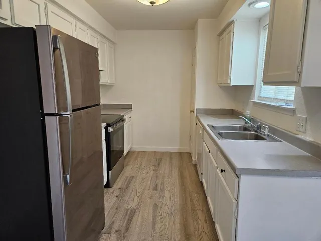 a kitchen with a sink a refrigerator and a stove