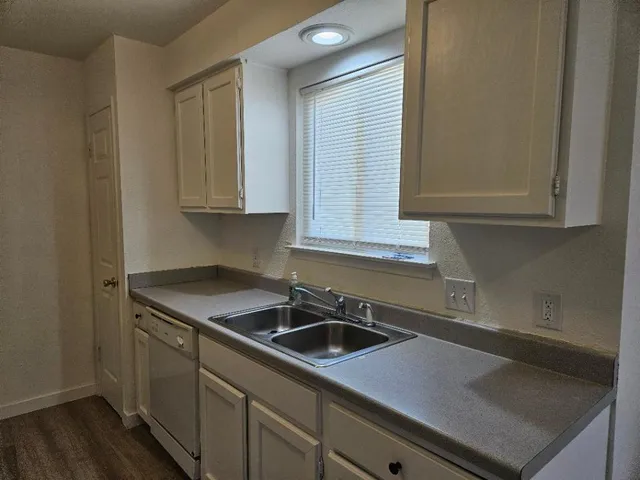 a kitchen with a sink cabinets and a window