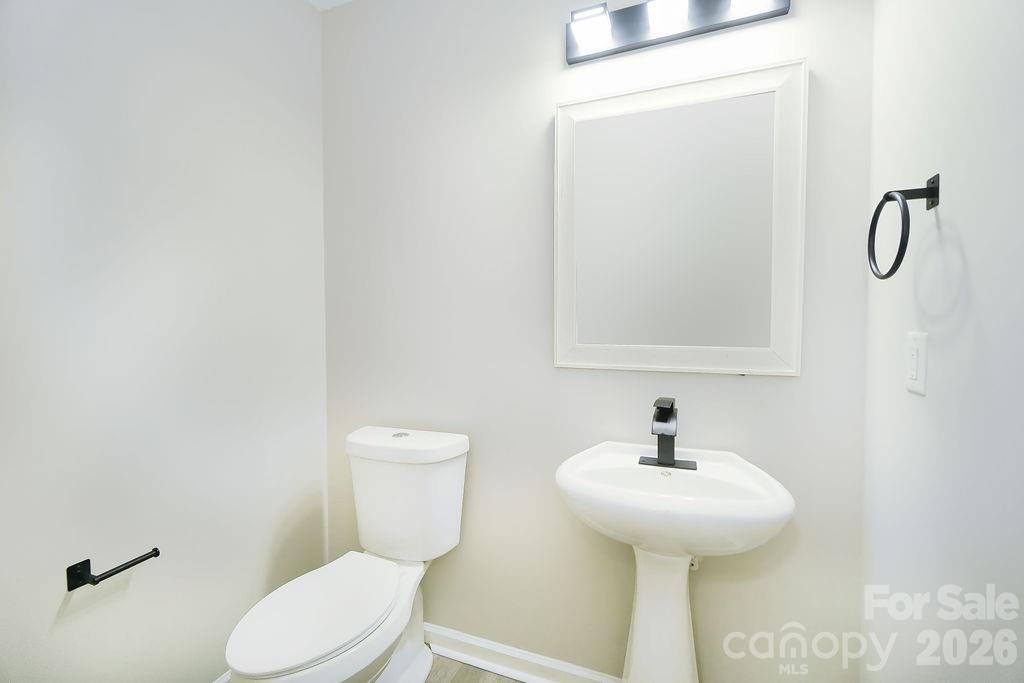 9614 Rau Court Charlotte, NC 28215 - Photo 14 of 21 a bathroom with a toilet sink and mirror