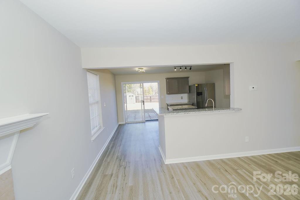9614 Rau Court Charlotte, NC 28215 - Photo 3 of 21 a view of a hallway with wooden floor and a living room