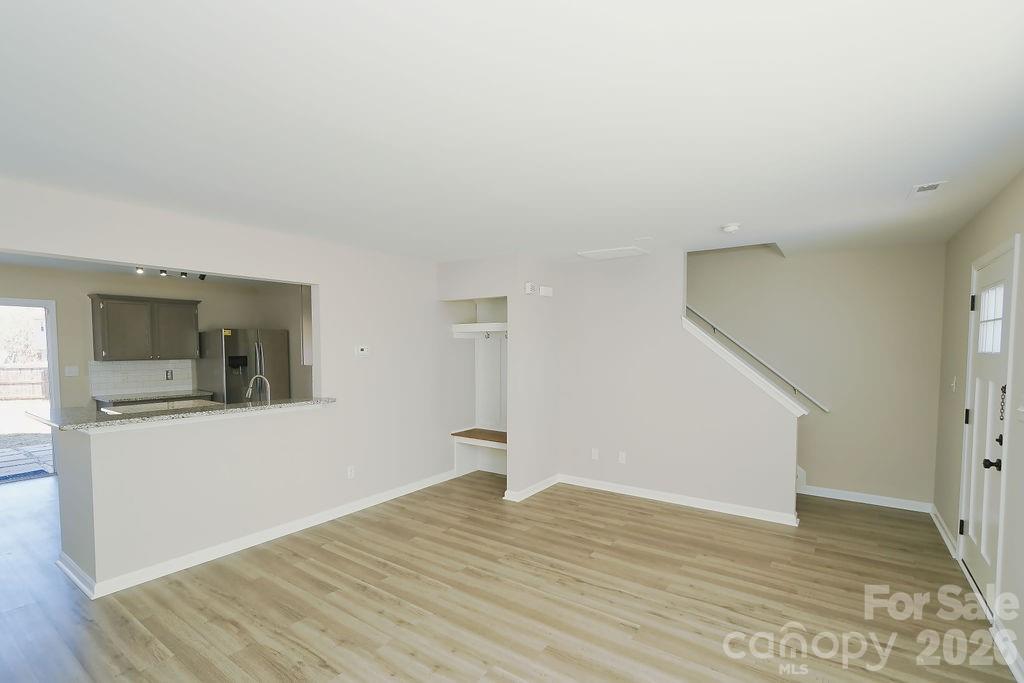 9614 Rau Court Charlotte, NC 28215 - Photo 4 of 21 a view of empty room with wooden floor and kitchen