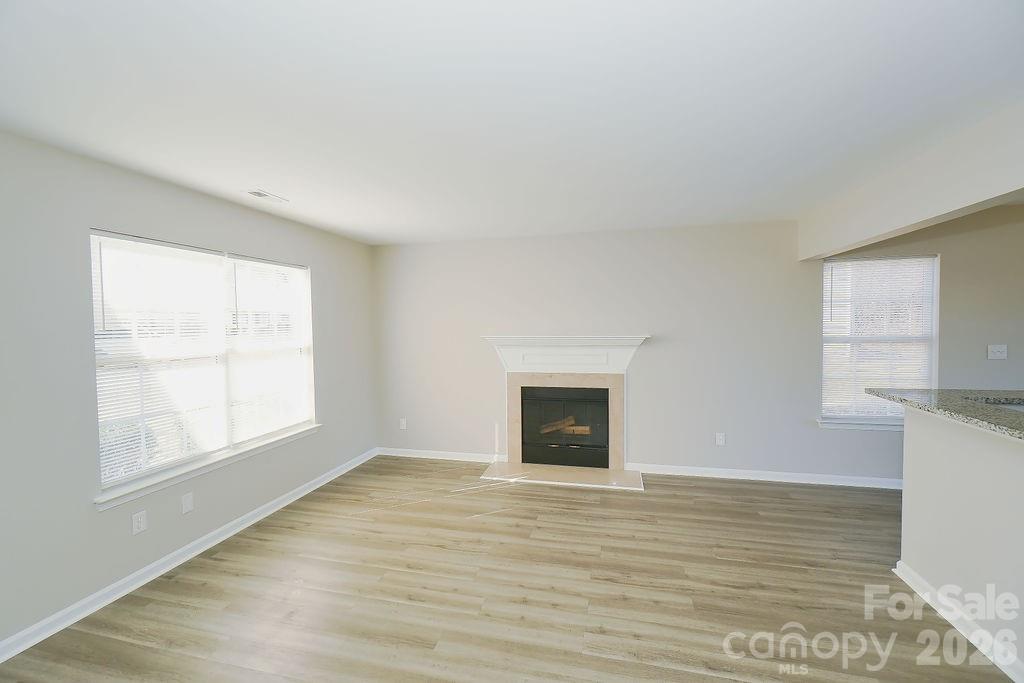 9614 Rau Court Charlotte, NC 28215 - Photo 5 of 21 a view of an empty room with wooden floor and a window