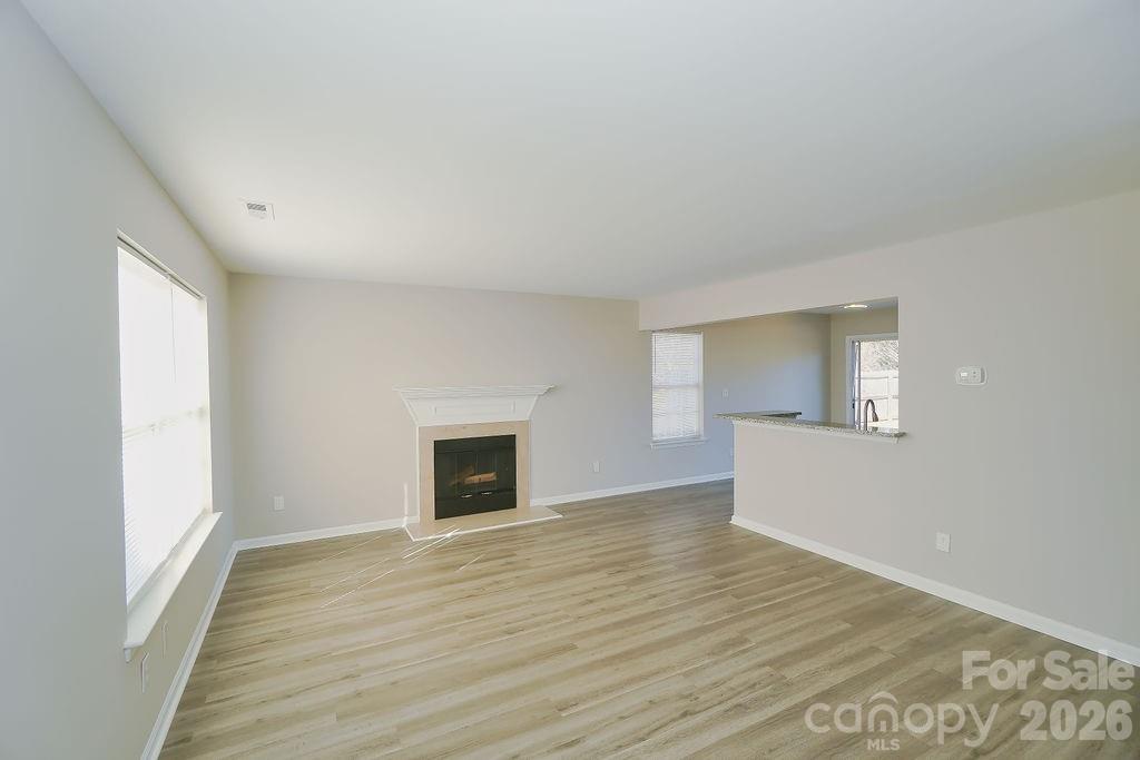 9614 Rau Court Charlotte, NC 28215 - Photo 10 of 21 a view of empty room with wooden floor and fan