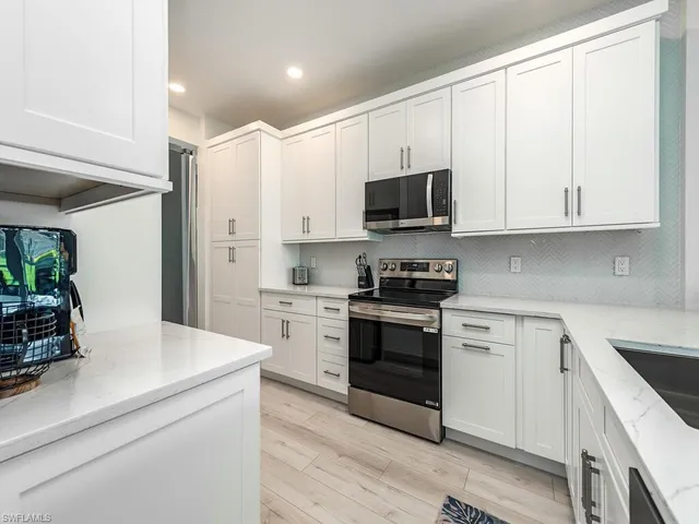 a kitchen with stainless steel appliances white cabinets and a sink
