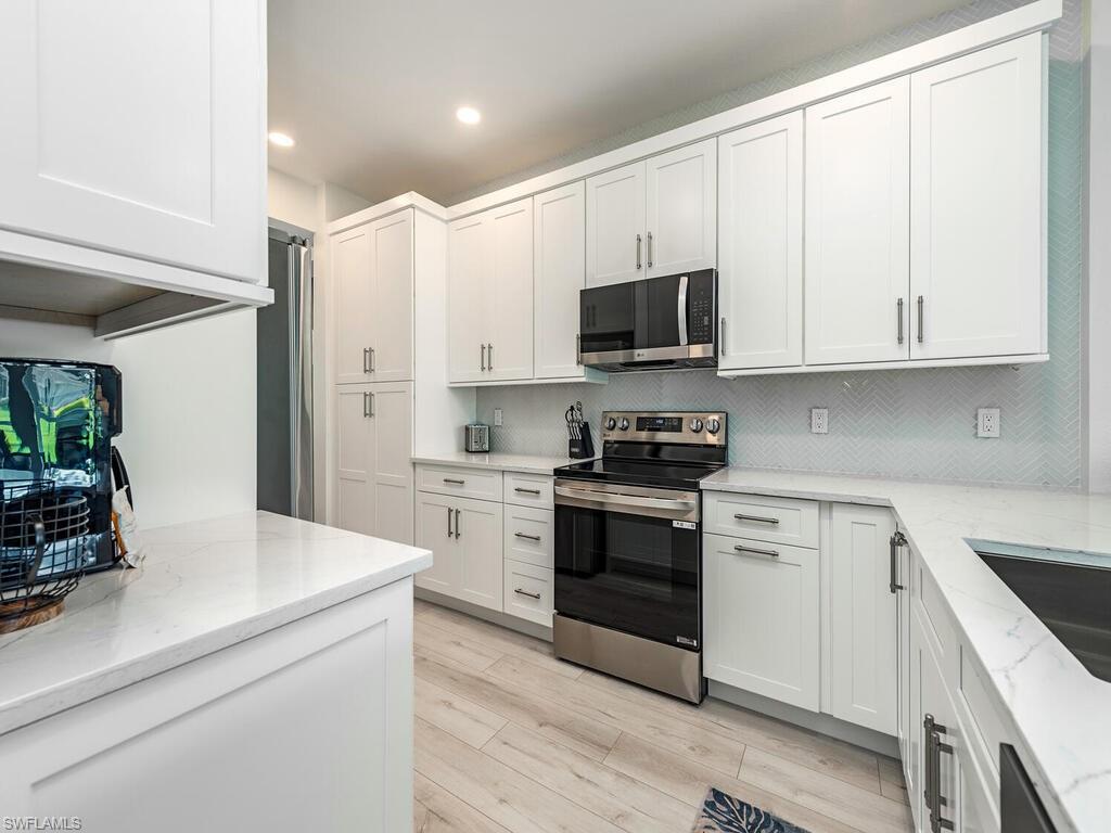 a kitchen with stainless steel appliances white cabinets and a sink