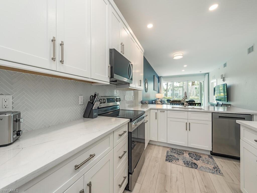 7970 Mahogany Run Lane, Unit 216 Naples, FL 34113 - Photo 2 of 29 a kitchen with a sink cabinets and stainless steel appliances