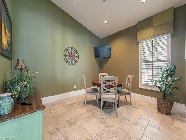 a dining room with wooden floor and a potted plant