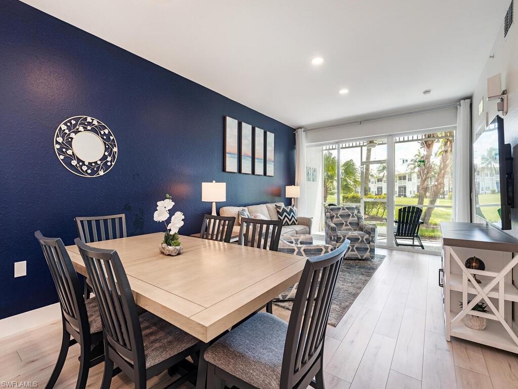 7970 Mahogany Run Lane, Unit 216 Naples, FL 34113 - Photo 4 of 29 a view of a dining room with furniture a chandelier and wooden floor