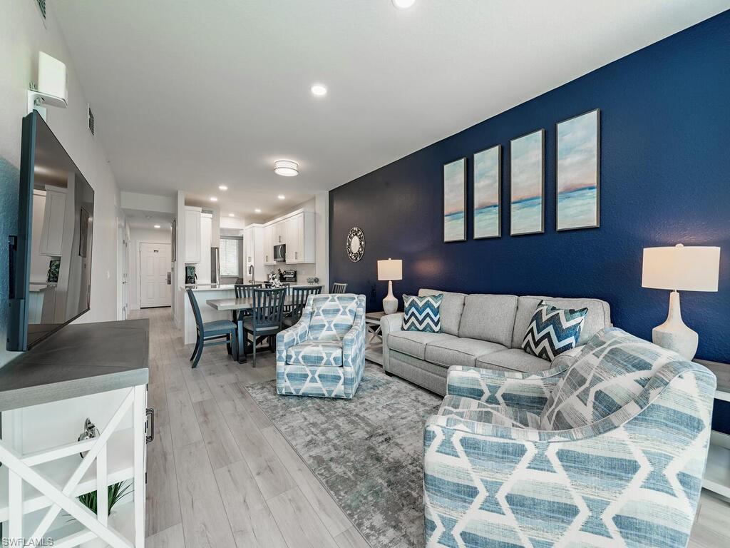 7970 Mahogany Run Lane, Unit 216 Naples, FL 34113 - Photo 6 of 29 a living room with furniture and a flat screen tv