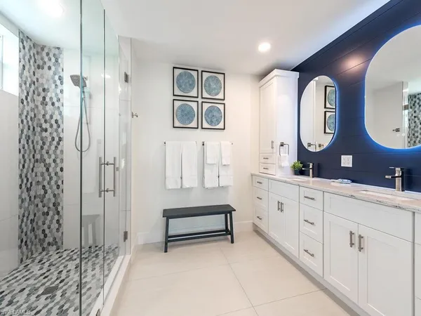a spacious bathroom with a double vanity sink mirror and shower