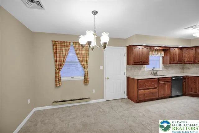 a kitchen with kitchen island granite countertop stainless steel appliances a stove top oven a sink and dishwasher