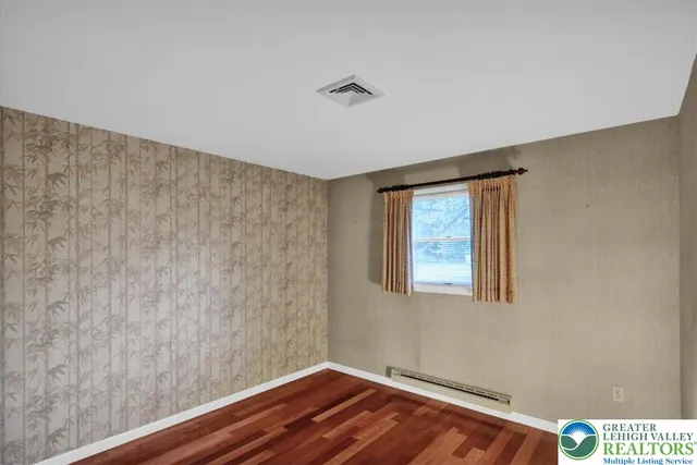 a view of room with window and wooden floor