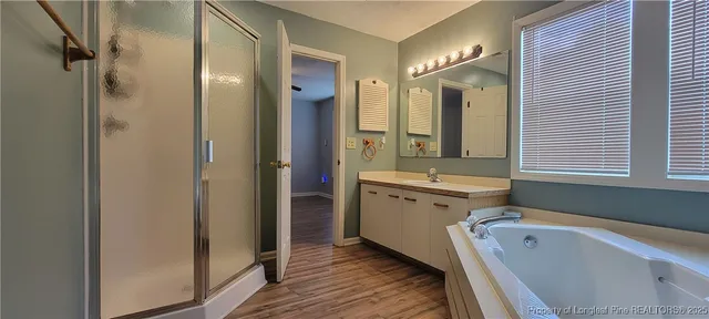 a bathroom with a tub sink shower and mirror