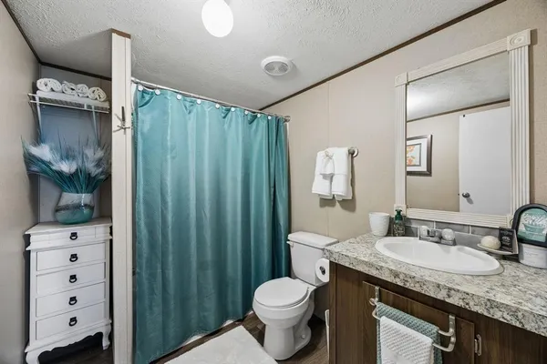 a bathroom with a granite countertop sink toilet and shower