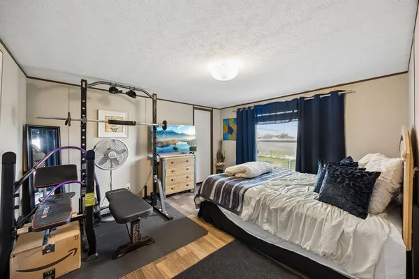 a bedroom with a bed a desk and chair with the large mirror