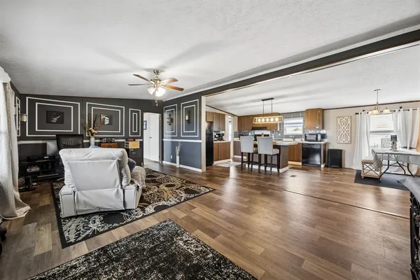 a living room with furniture a wooden floor and a chandelier