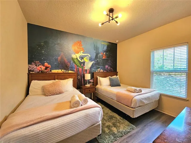 a bedroom with two beds and painting on the wall