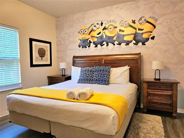 a bedroom with a bed and painting on the wall