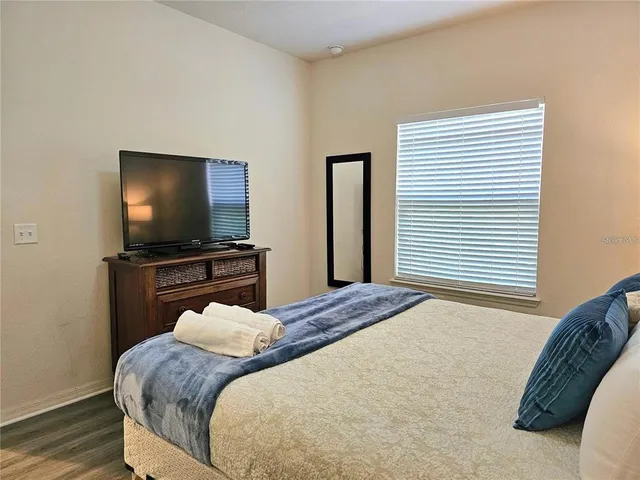 a bedroom with a bed and a flat screen tv