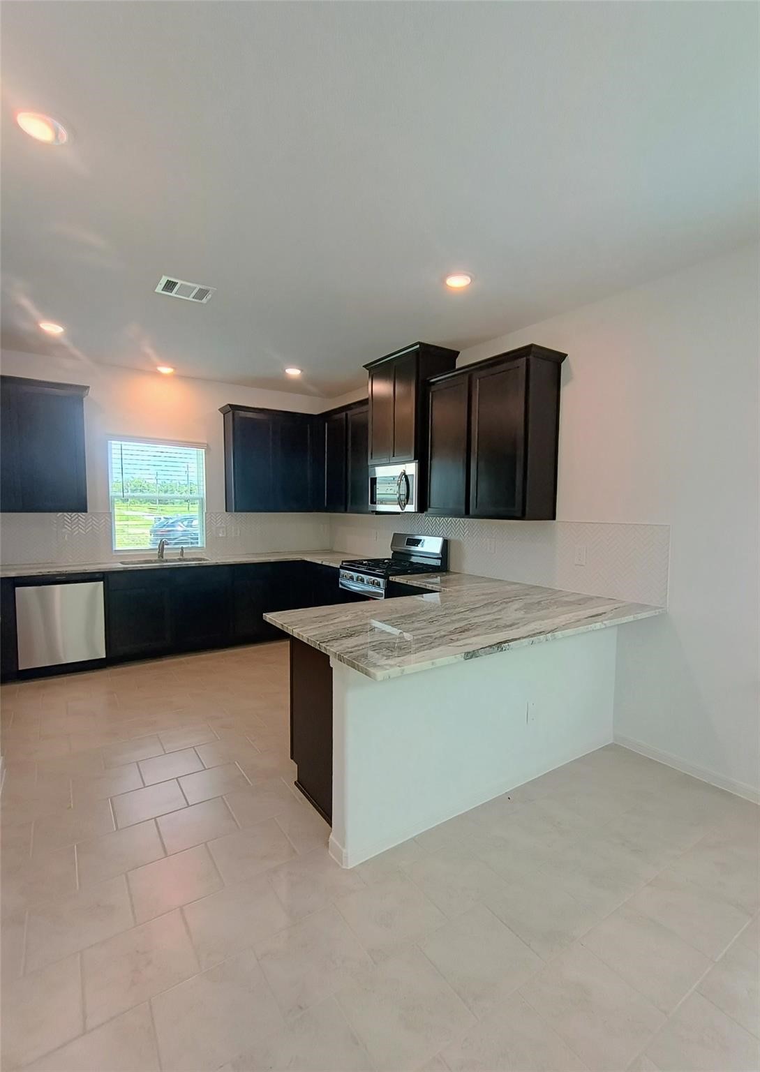 15924 Cy Young Court Splendora, TX 77372 - Photo 7 of 29 a large kitchen with a large counter top stainless steel appliances and cabinets