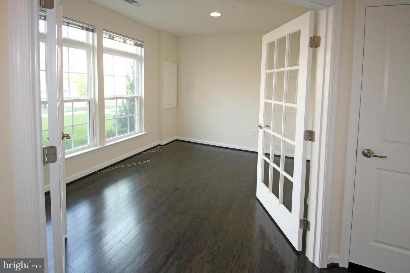 2482 Baldwin Crescent Northeast Washington, DC 20018 - Photo 3 of 28 an empty room with wooden floor and windows