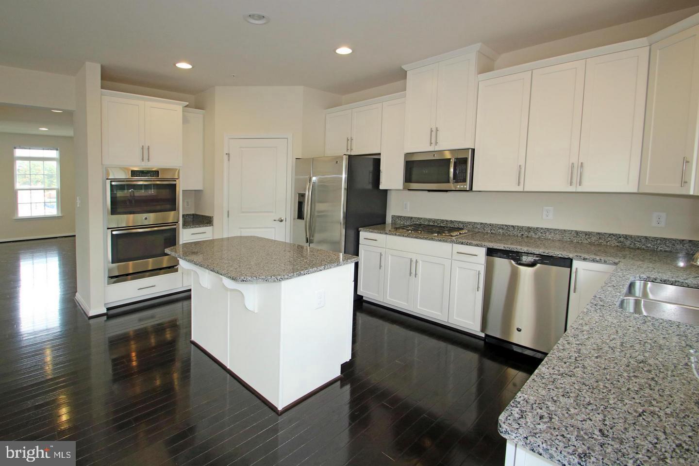 2482 Baldwin Crescent Northeast Washington, DC 20018 - Photo 8 of 28 a kitchen with granite countertop white cabinets and stainless steel appliances