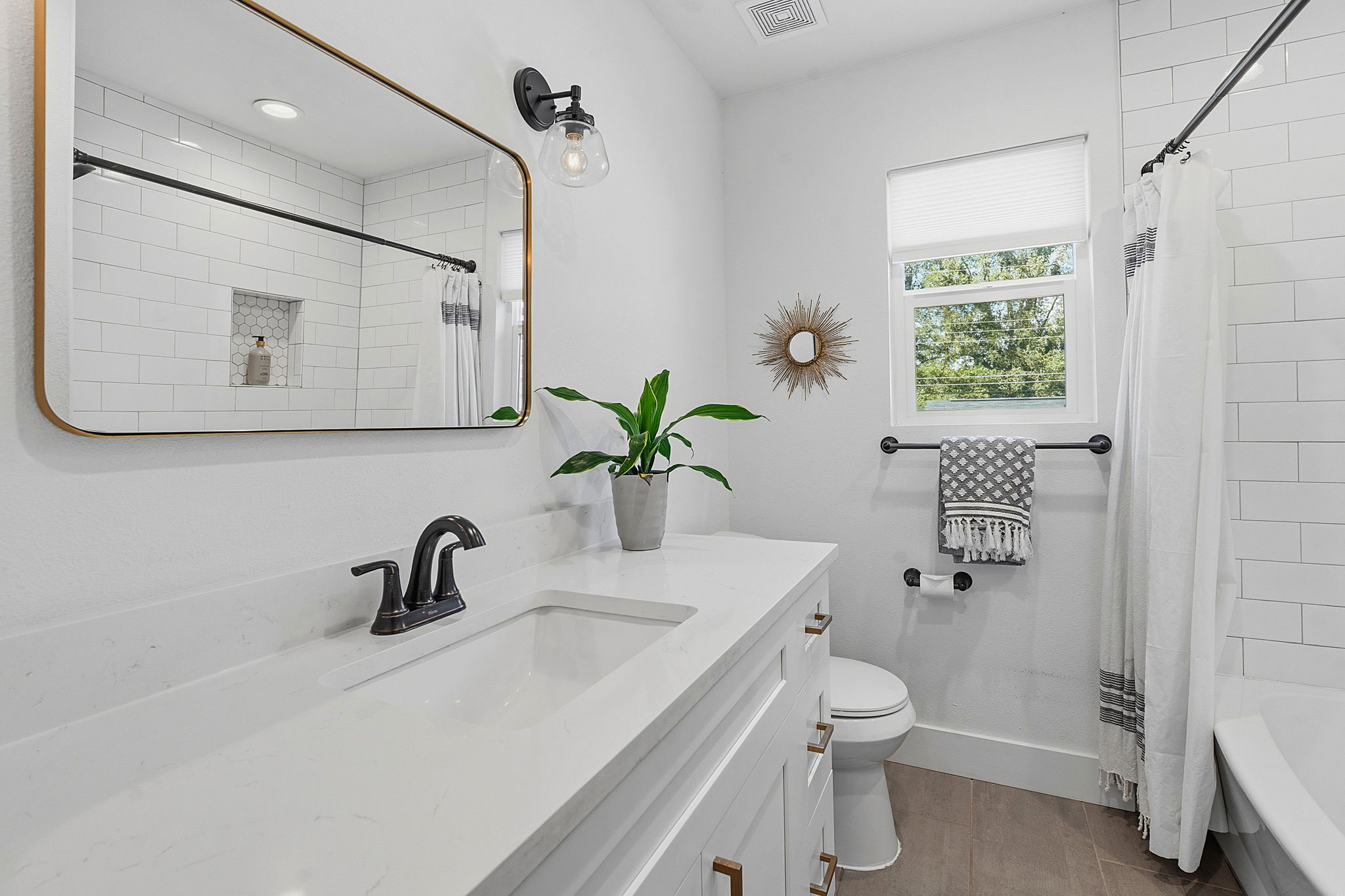 4403 Elmsgrove Drive Austin, TX 78721 - Photo 13 of 38 A well-lit bathroom showcases a pristine vanity with ample counter space and a modern toilet.