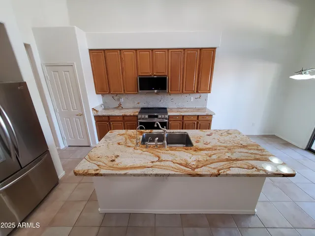 a kitchen with stainless steel appliances granite countertop a sink and a stove