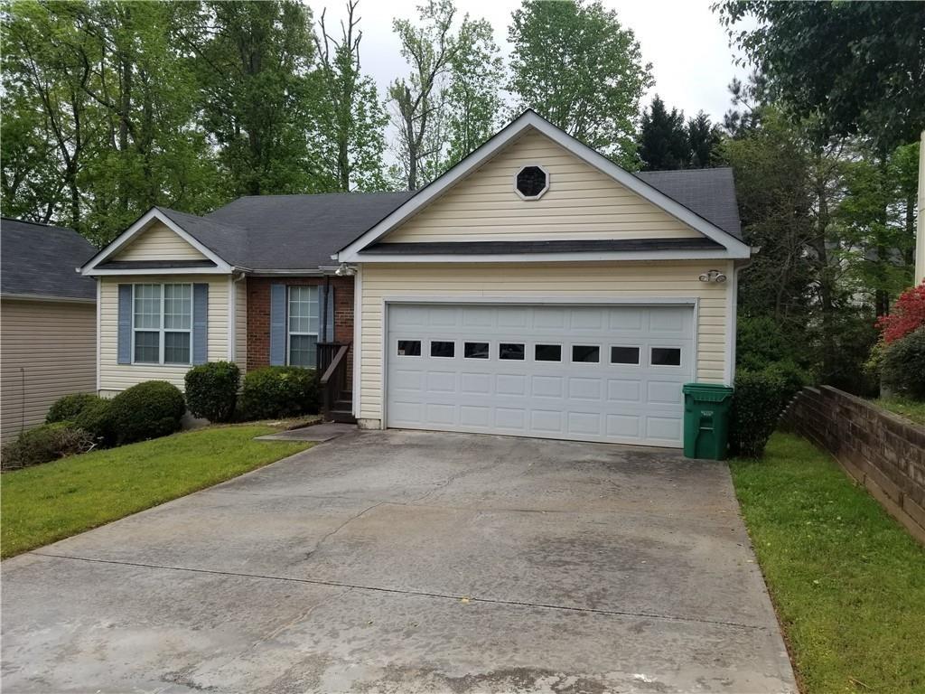 692 Shore Overlook Lithonia, GA 30058 - Photo 1 of 4 a front view of a house with a yard and garage