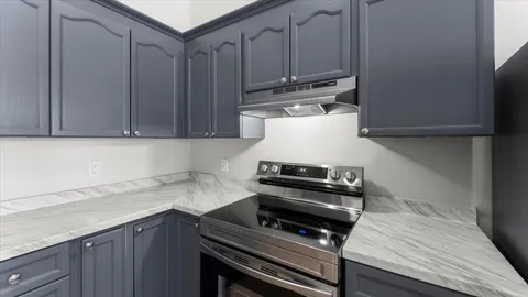 a kitchen with wooden cabinets and a stove top oven