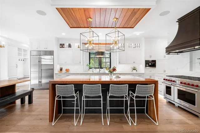 a kitchen with stainless steel appliances granite countertop a table chairs sink and cabinets