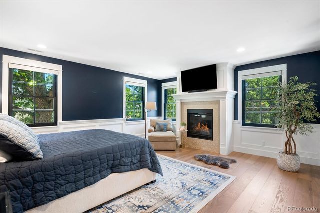 a bedroom with a large bed and a flat tv screen on dresser