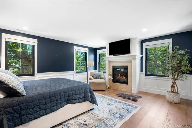a bedroom with a large bed and a flat tv screen on dresser