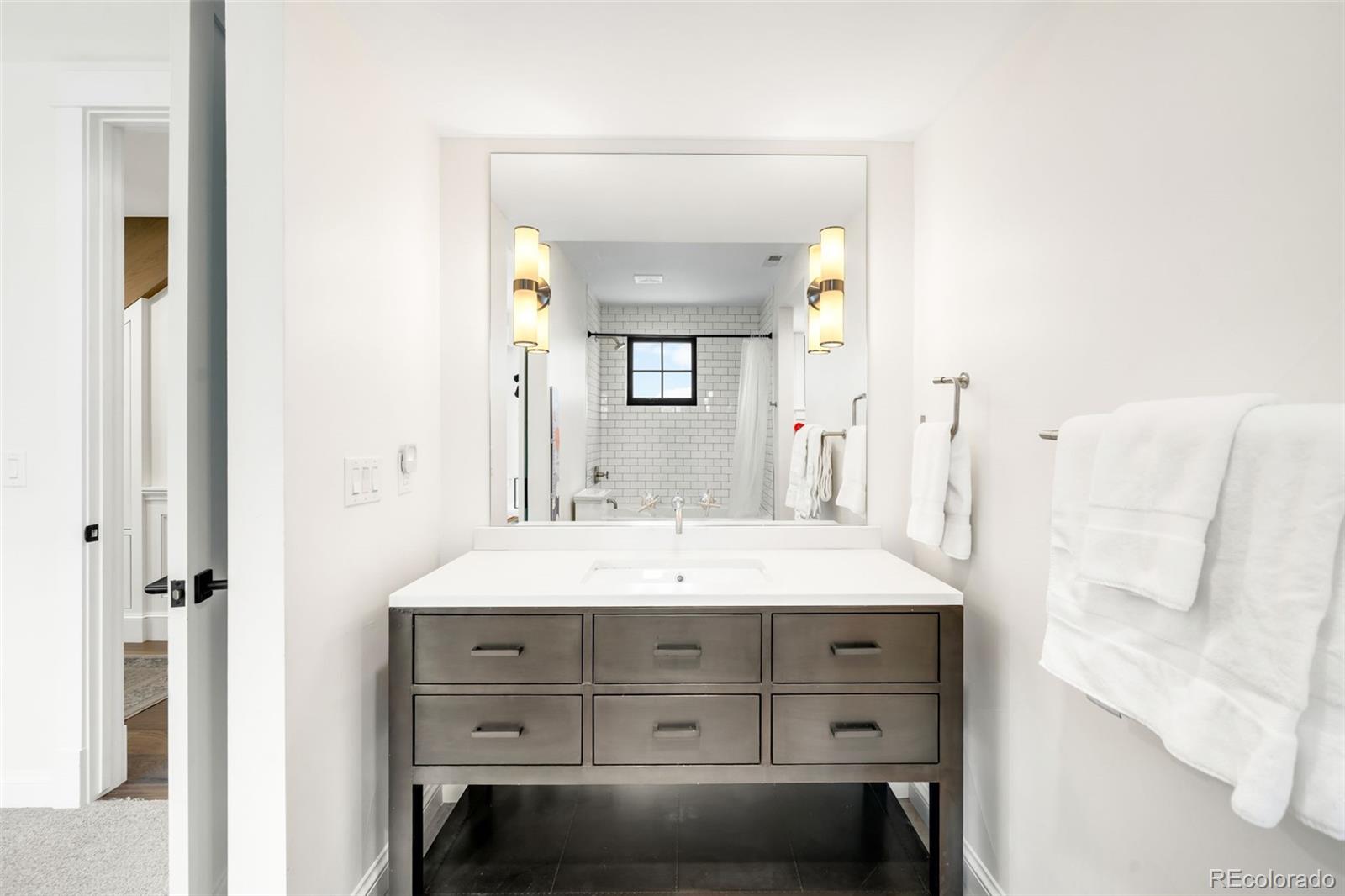 1296 South York Street Denver, CO 80210 - Photo 31 of 49 a bathroom with a sink and a mirror