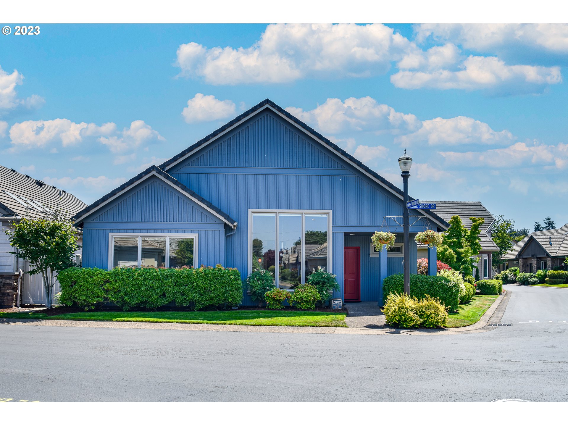 a front view of a house with a yard and potted plants