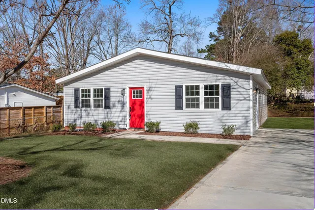 a front view of a house with a yard and trees