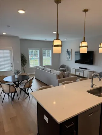 a living room with furniture a flat screen tv and a window