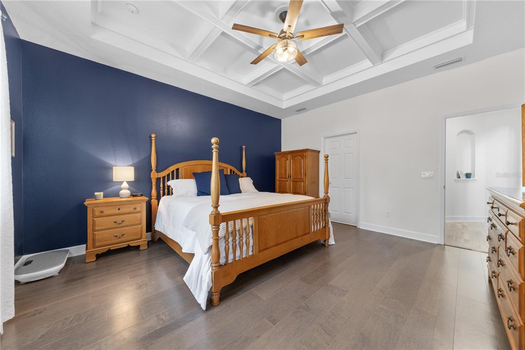 16948 Deer Island Road Tavares, FL 32778 - Photo 16 of 67 a bedroom with a bed and a chandelier