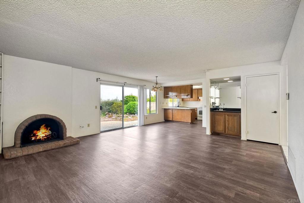 3579 Twilight Lane Oceanside, CA 92056 - Photo 7 of 30 a view of a living room a kitchen with wooden floor and a floor to ceiling window