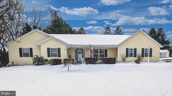 front view of a house with a yard covered in snow