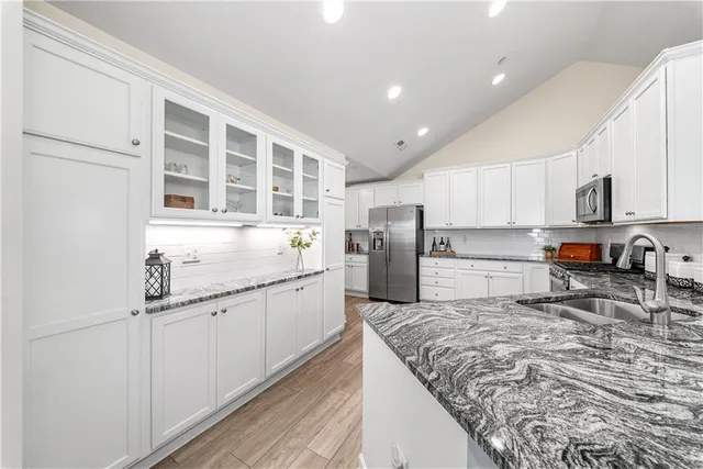 a kitchen with stainless steel appliances granite countertop a refrigerator sink and cabinets