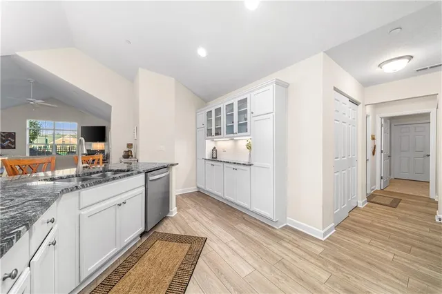 a kitchen with white cabinets and sink