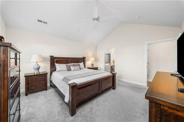 a bedroom with a bed and a potted plant on the dresser