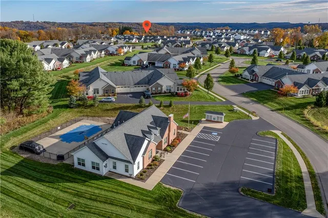 an aerial view of a house with a garden and lake view