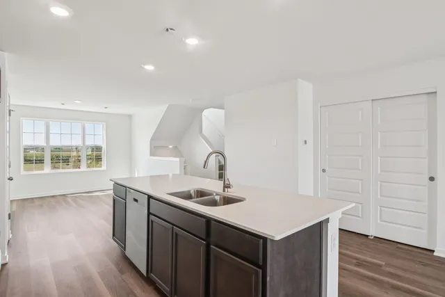 a kitchen with a sink cabinets and wooden floor