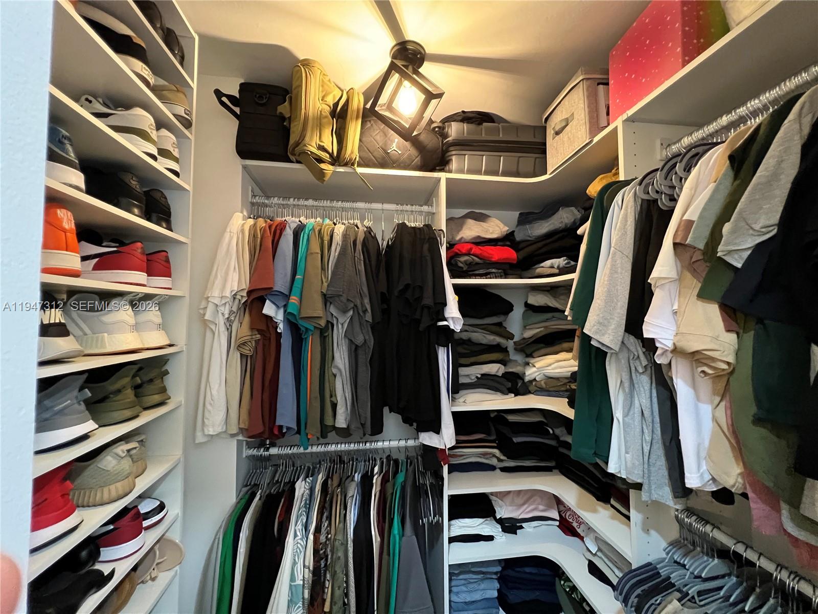 8425 Northwest 8th Street, Unit 406 Miami, FL 33126 - Photo 12 of 22 a view of walk in closet with clothes and shoes