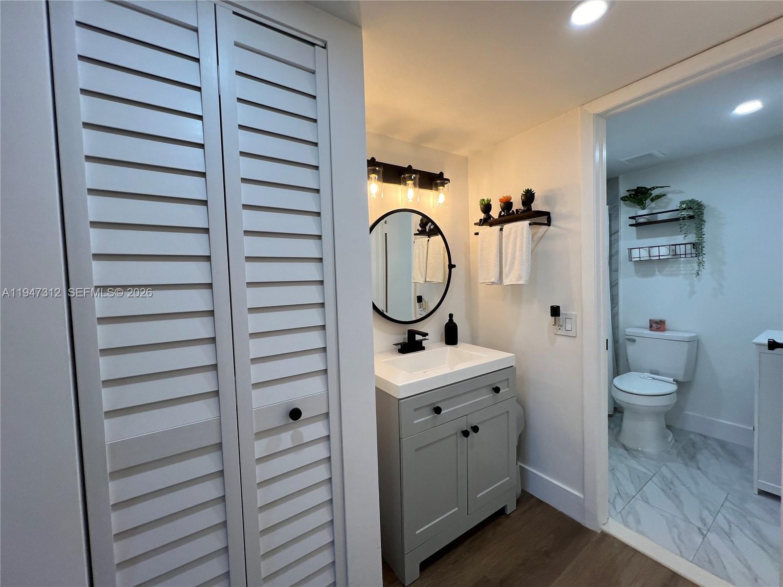 8425 Northwest 8th Street, Unit 406 Miami, FL 33126 - Photo 16 of 22 a bathroom with a toilet a sink and a mirror