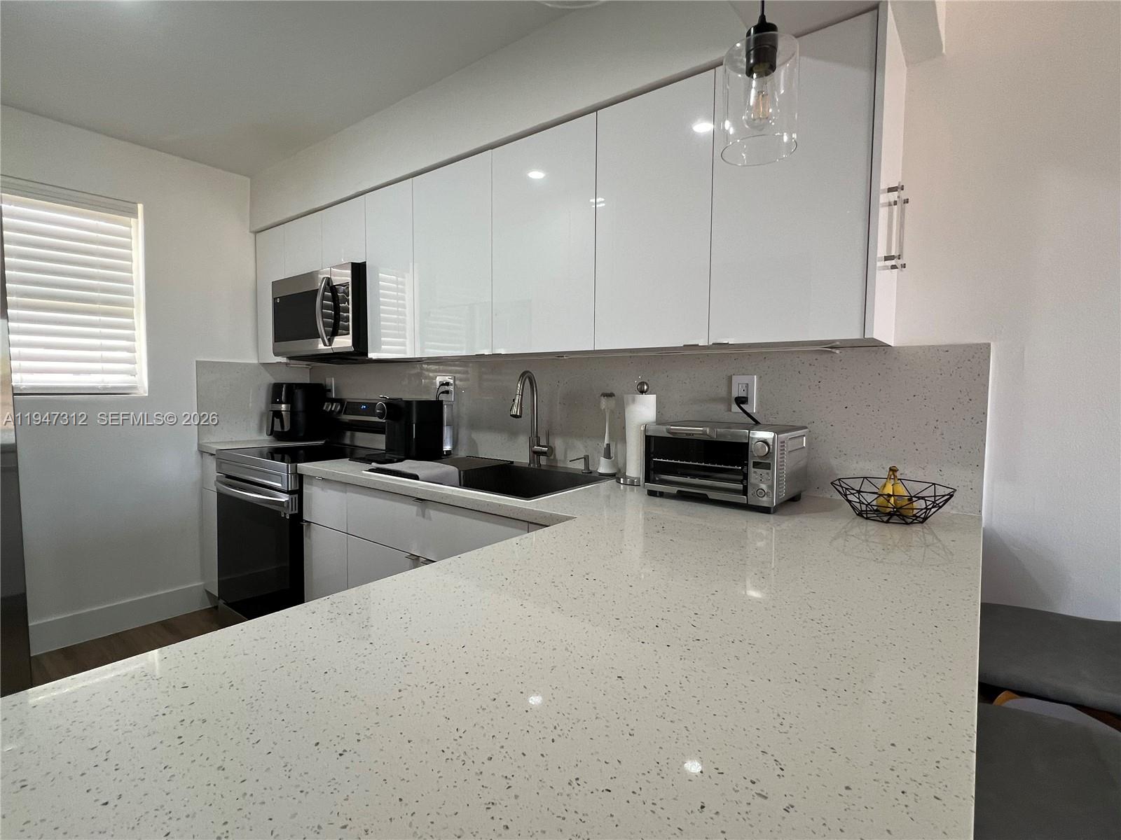 8425 Northwest 8th Street, Unit 406 Miami, FL 33126 - Photo 2 of 22 a kitchen with a sink a stove and cabinets