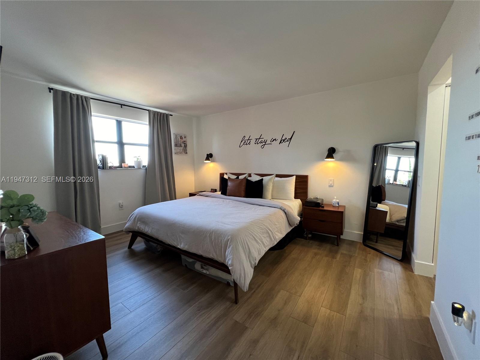 8425 Northwest 8th Street, Unit 406 Miami, FL 33126 - Photo 7 of 22 a bedroom with a bed and wooden floor