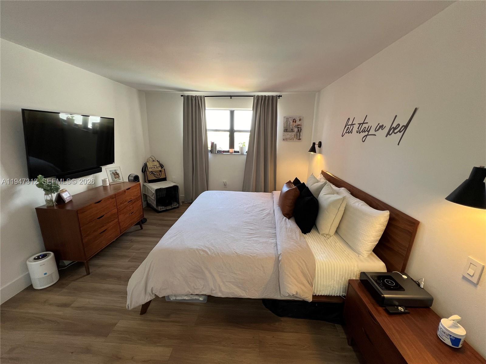 8425 Northwest 8th Street, Unit 406 Miami, FL 33126 - Photo 8 of 22 a bedroom with bed table and flat screen tv